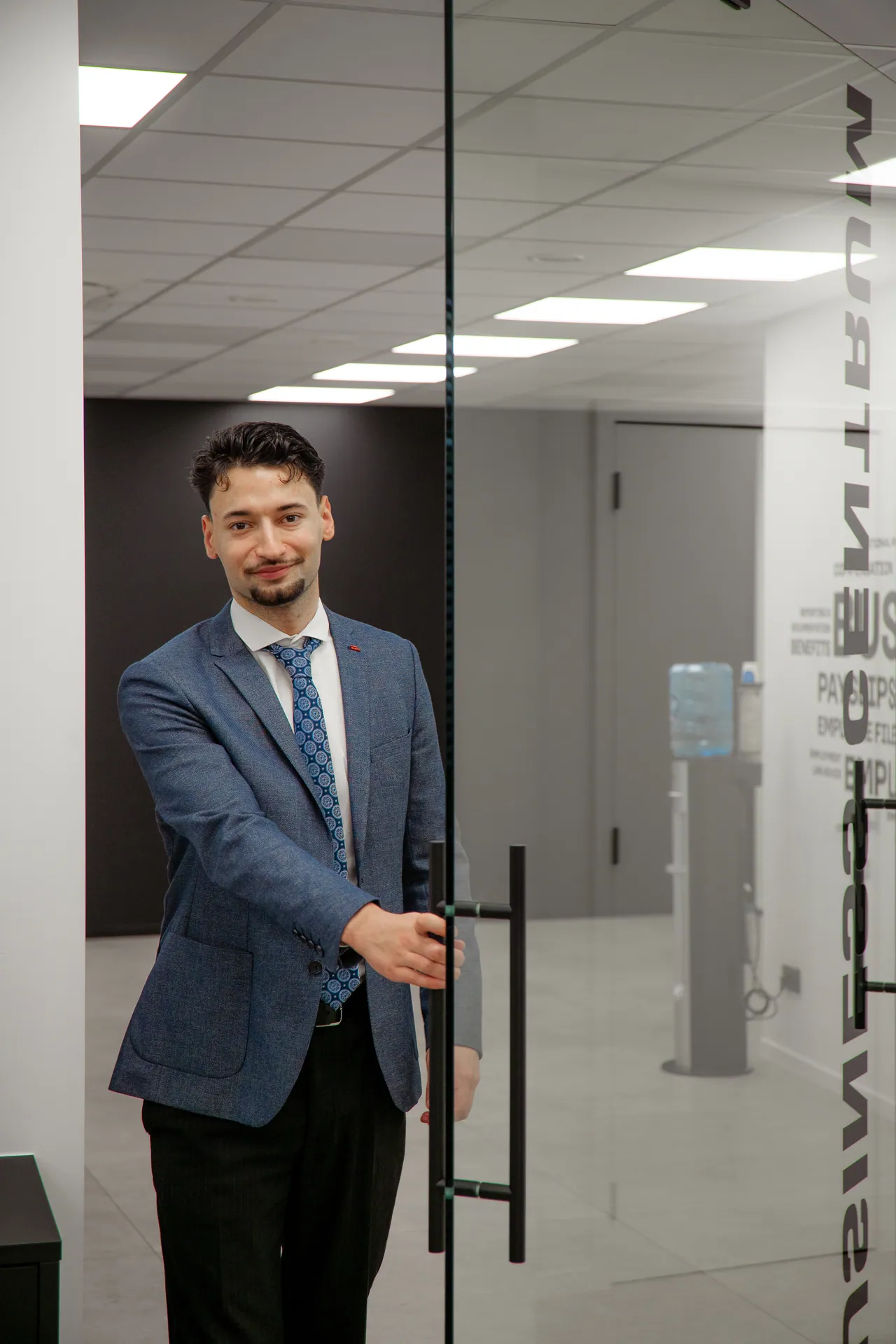 Collega houdt de glazen voordeur open